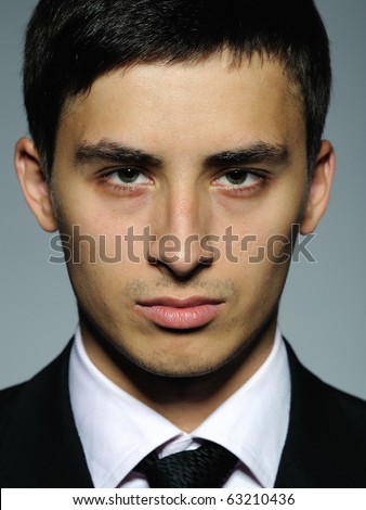 Portrait of serious business man in formal suit and black tie . expressions on gray background