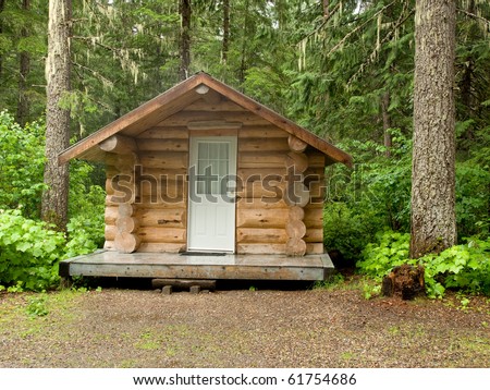 A small log cabin in a forest of trees