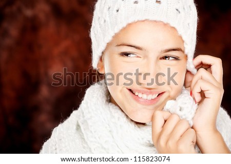 young happy brunette woman in wool sweater and cap, isolated on white