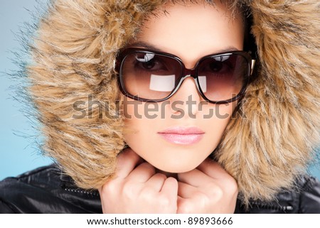 pretty woman wearing winter outfit with fur and glasses