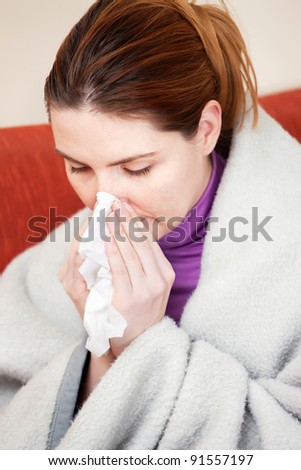 Young woman sneezing in the handkerchief