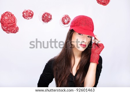 Pretty woman with red hat between red balls