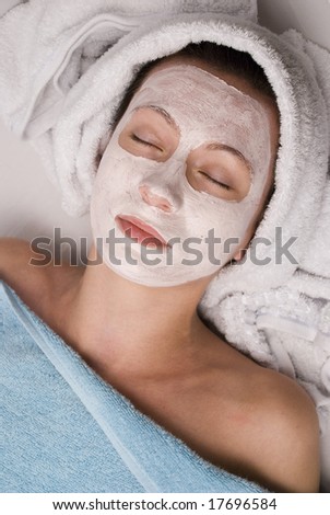 A beautiful young brunette woman rests after having a clean face mask