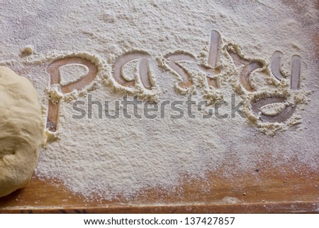 Background with word pastry in scattering flour on wooden table