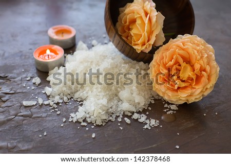 Sea salt  with rose and candles on wooden background.  Selective focus.Spa/wellness products.