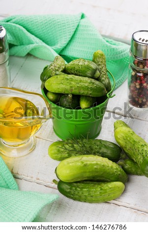 Fresh organic cucumbers in bucket on white wooden table. Selective focus. Natural/organic/bio/healthy products.