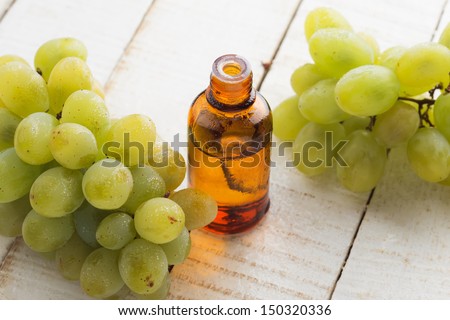 Grape seed oil in bottle on white wooden background. Selective focus. Bio/organic/eco products.