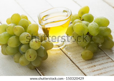 Grape seed oil  on white wooden background. Selective focus. Bio/organic/eco products.