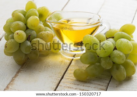 Grape seed oil on white wooden background. Selective focus. Bio/organic/eco products.