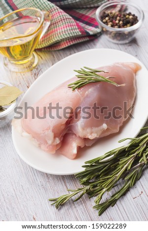 Fresh chicken meat on  plate on white table with spices. Selective focus. Rustic style.
