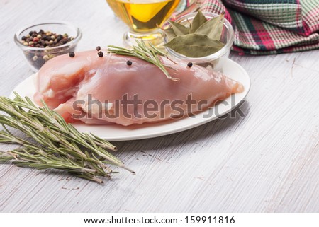 Fresh chicken meat plate on white table with spices. Selective focus. Rustic style.