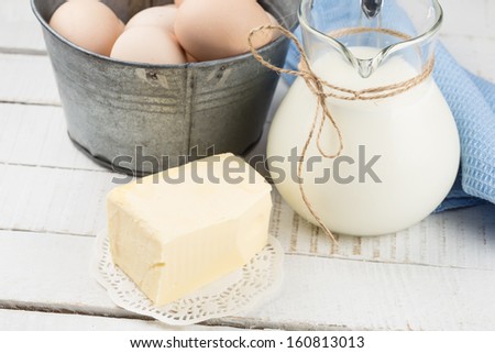 Fresh butter, milk, eggs  on white table. Selective focus. Rustic style.