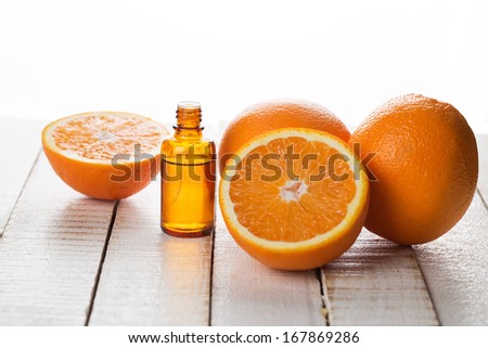 Essential aroma oil with oranges on wooden background. Selective focus.