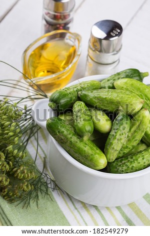 Fresh organic cucumbers in bowl on white wooden table. Selective focus. Natural/organic/bio/healthy products.