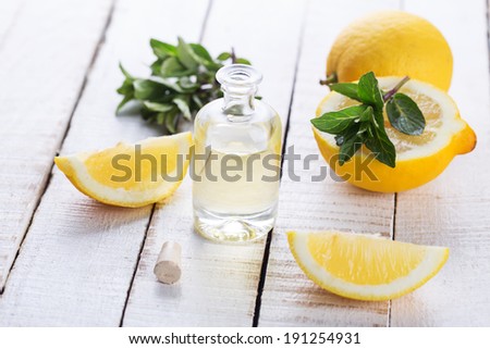 Essential aroma oil with lemon and mint on wooden background. Selective focus, horizontal.