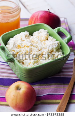 Fresh dairy products - cottage cheese, honey, apple on colorful napkin on white table. Rustic style. Bio/organic/natural ingredients. Healthy eating.