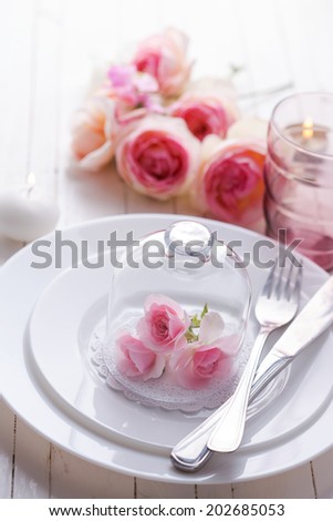 Romantic table setting.Roses on plate.  Selective focus.
