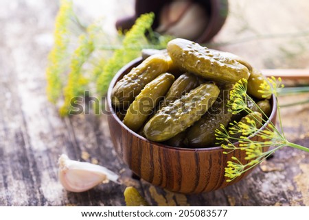 Pickled organic cucumbers in bowl on  wooden table. Selective focus. Natural/organic/bio/healthy products.