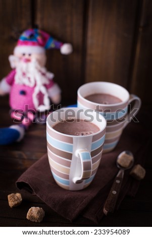 Christmas cocoa in mug  on wooden background. Selective focus is on the first  mug.