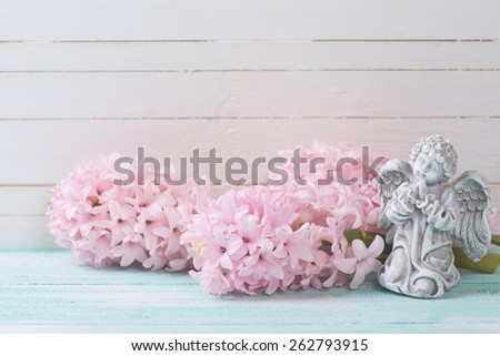 Postcard with fresh flowers hyacinths  and angel on turquoise painted wooden planks. Selective focus.