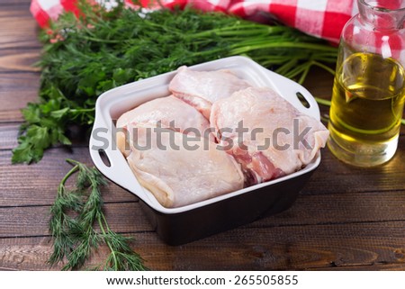 Fresh chicken meat in bowl  on painted wooden planks. Selective focus. Rustic style.