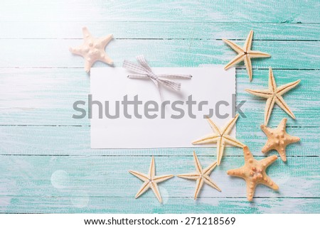 Marine items on wooden background. Sea objects  in ray of light on turquoise painted wooden planks. Empty tag for text. Selective focus.