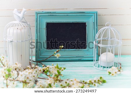 Postcard with white  branches  and candles  and empty blackboard on turquoise painted wooden planks against white wall. Selective focus is on blackboard.  Place for text. Toned image.