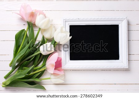 Postcard with fresh white and pink flowers and empty blackboard for your text on white painted planks. Selective focus.