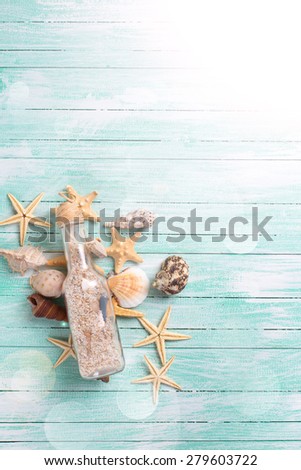 Different marine items  in ray of light on turquoise painted wooden background. Sea objects on wooden planks. Selective focus.