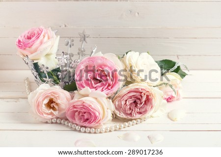 Background with sweet pink roses  on white painted wooden background. Selective focus. Toned image.