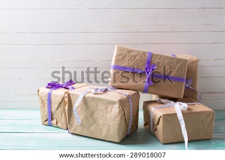 Wrapped boxes with presents on turquoise painted wooden planks against white wall. Selective focus. Place for text.