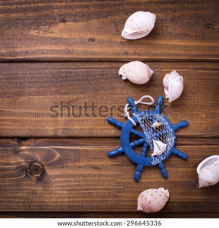 Decorative helm and marine items on wooden background.  Selective focus. Place for text. Square image.