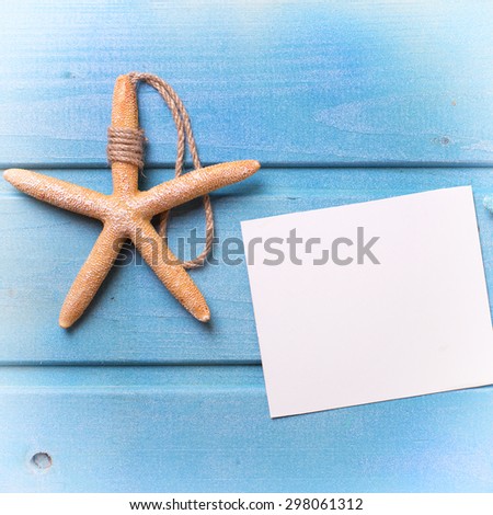 Marine items and empty tag on blue wooden background. Sea objects on wooden planks. Selective focus. Place for text. Square image.