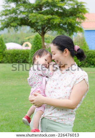 Asian mom with her baby in garden