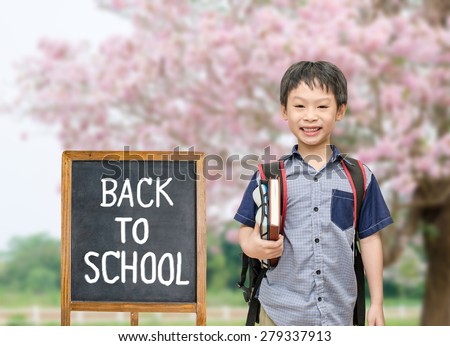 Asian student with back to school board at school garden