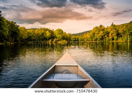Aluminum canoe on a mountain lake upstate New York. Camping. outdoors and adventure concept.  Faded, vintage color post processed Stok fotoğraf © 