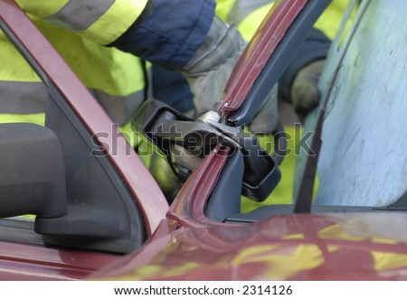 Fire crew cutting door pillar on car