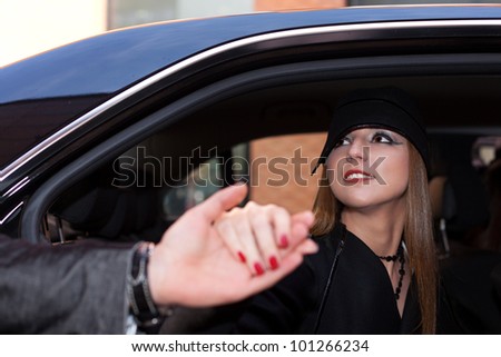 Lady accepting man\'s helping hand for getting out of the car