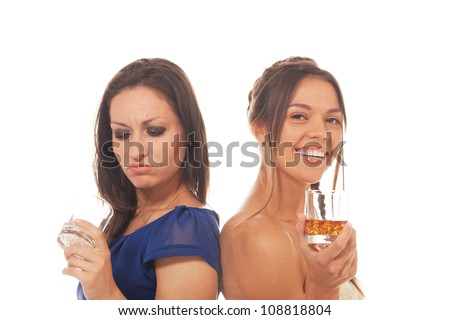One girl is disappointed because of empty glass while other is happy to have it filled