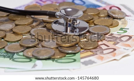 euro coins with banknotes and stethoscope