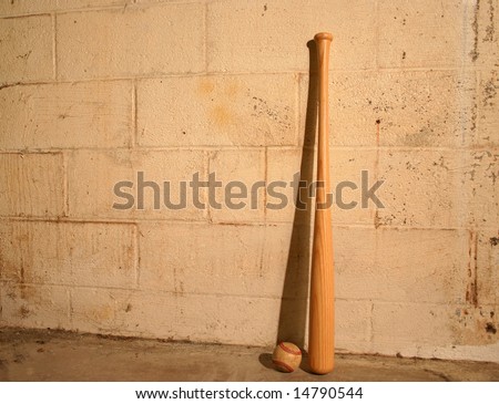 Bat and old baseball against old dirty wall.