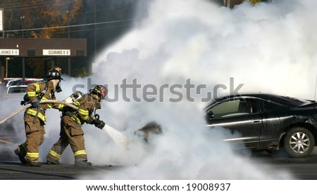 Firemen extinguishing a car fire.