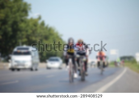 blur photo people and bike are cycling on the road