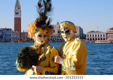 VENICE, ITALY - FEBRUARY 24: The carnival of Venice is held in Italy. Beautiful couple in colorful costumes and masks, view on Piazza San Marco. Wonder and Fantasy Nature. Venice, Italy - Feb 24, 2014