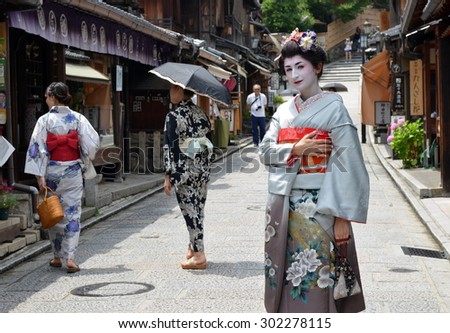 KYOTO, JAPAN - JULY 2: Maiko walking in Kyoto street. Apprentice geisha in Japan. Their jobs consist of performing songs, dances, and playing the shamisen. Kyoto, Japan - July 2, 2015