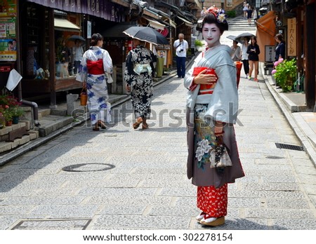 KYOTO, JAPAN - JULY 2: Maiko walking in Kyoto street. Apprentice geisha in Japan. Their jobs consist of performing songs, dances, and playing the shamisen. Kyoto, Japan - July 2, 2015