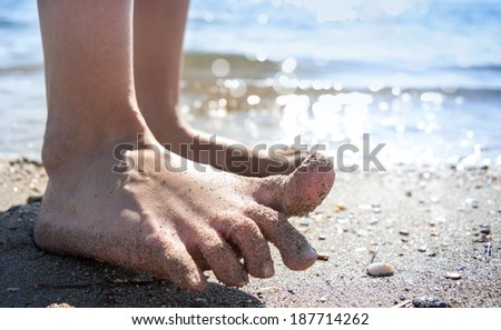 Funny feet closeup with bokeh summer sea background