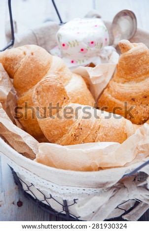 Fresh croissants with jam for breakfast in a basket