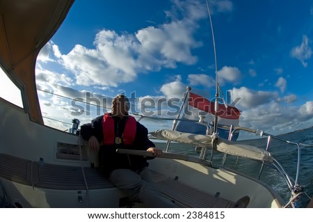 Captain of sailing yacht at the helm
