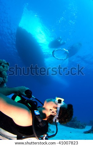 Diver with big bubble with dive boat
